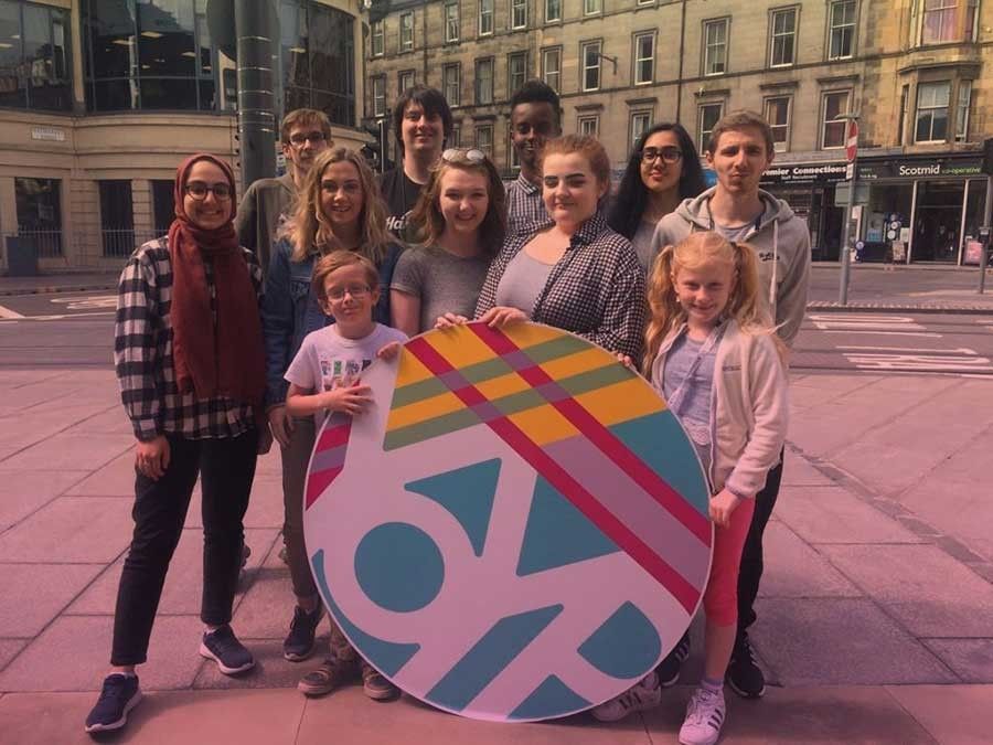 A group of young people hold the Year of Young People sign.