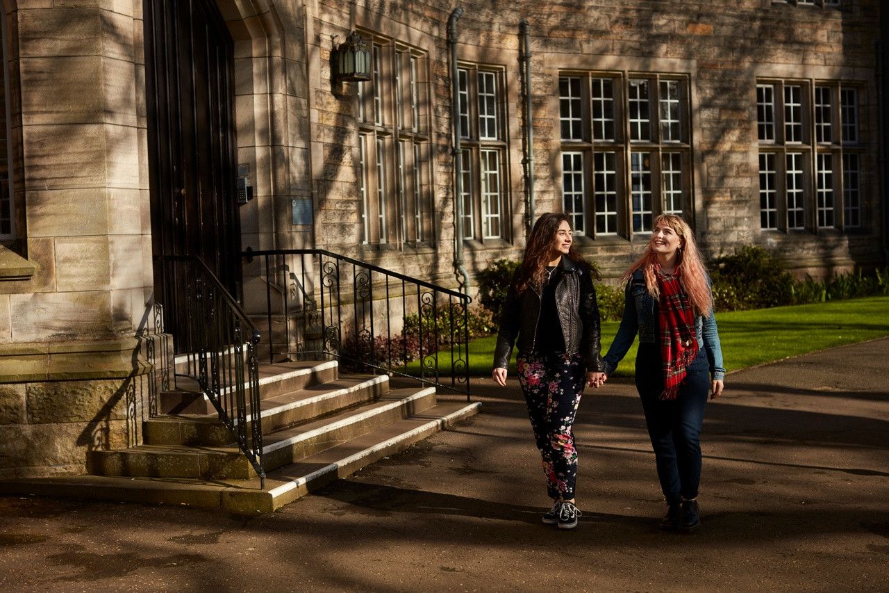Two students walking in the grounds of the University of St Andrews